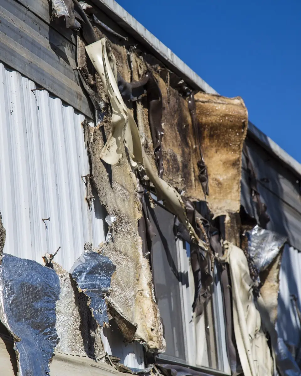 A fire-damaged exterior wall with exposed insulation